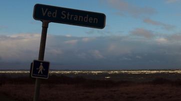 VED STRANDEN - LYSTRUP STRAND, skævt skilt i blæsevejr